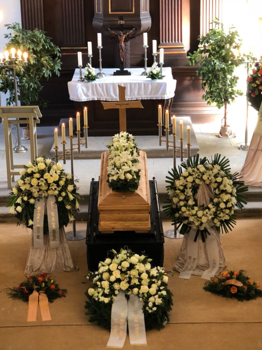 Dekorationsbeispiel Sarg in Kirche mit Blumensträußen