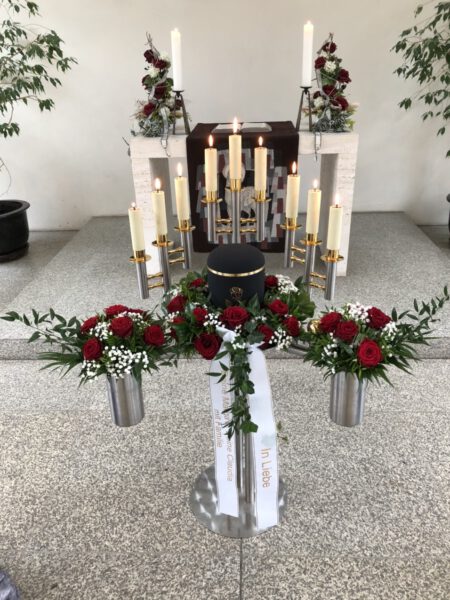 Rosen und Kerzendekoration bei einer Urnenbeisetzung