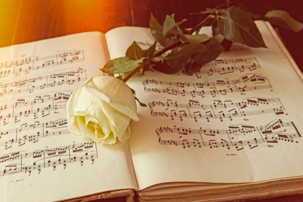 Musiknoten mit Rose Trauerfeier