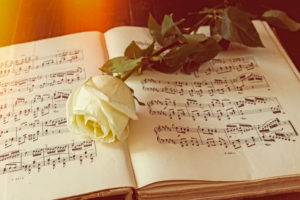 Musiknoten mit Rose Trauerfeier