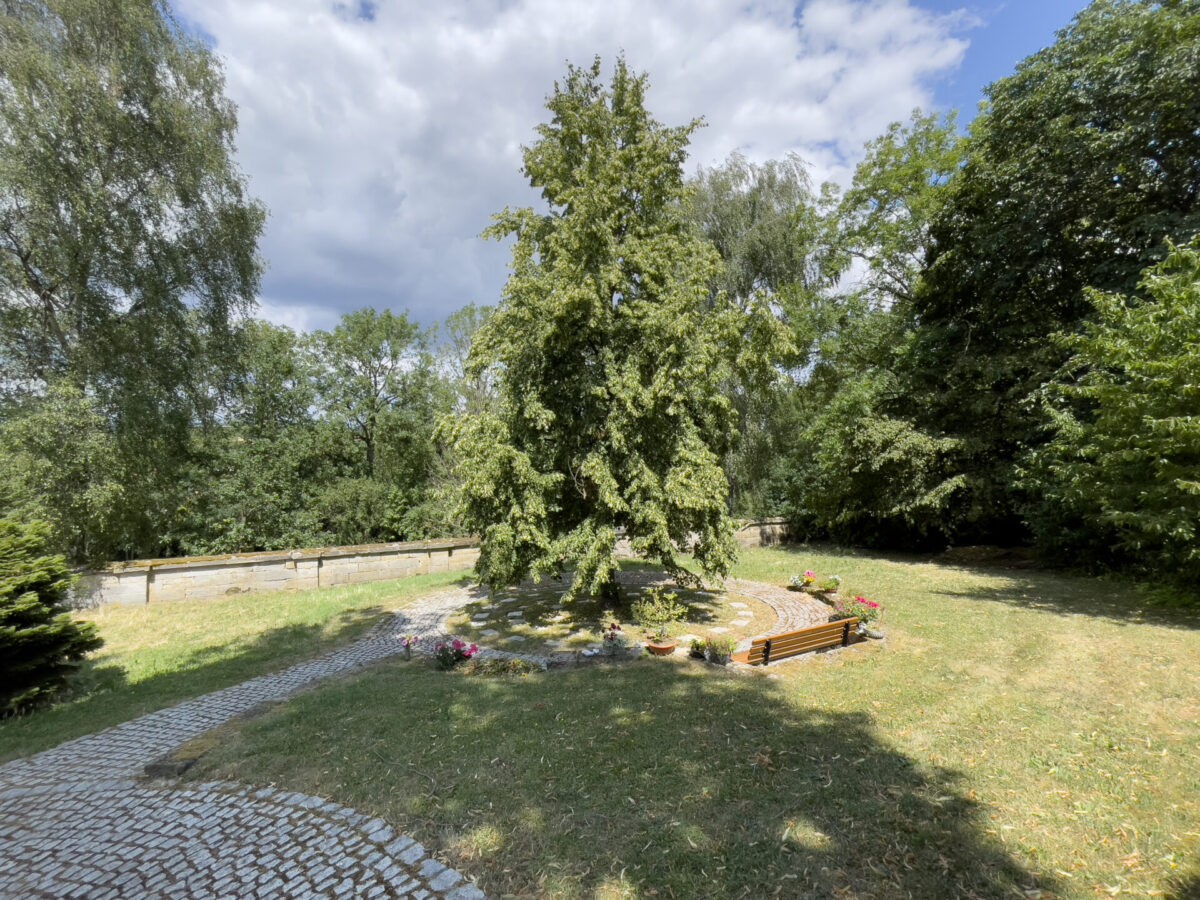 Baumgrab am Friedhof Gesees mit Blumen und Bank