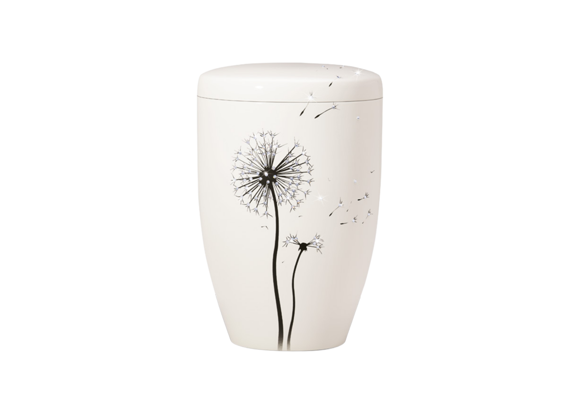 Eine weiße Edition Kremationsurne mit einem einfachen Design von zwei schwarzen Pusteblumen und Samen, die im Wind wehen, vor einem schlichten Hintergrund.