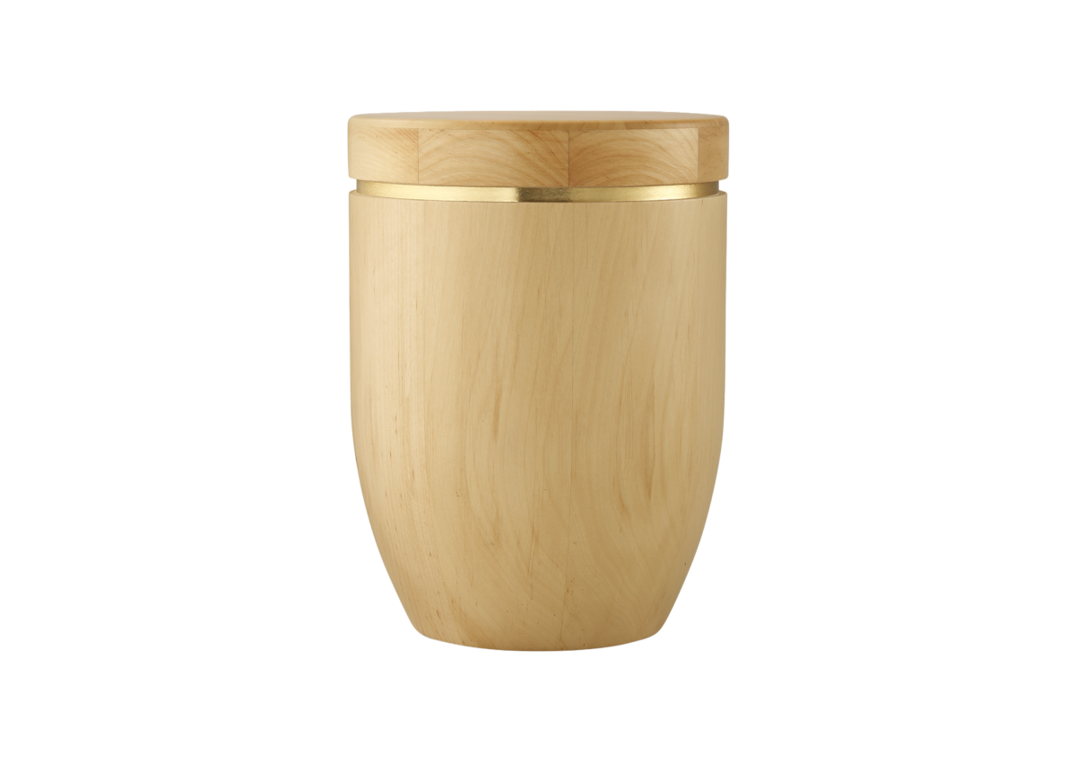 Ein heller, hölzerner Cocktailshaker aus der Kollektion Edition HolzPur mit glatter Oberfläche und einem goldenen Metallband im oberen Bereich, der aufrecht vor einem schlichten weißen Hintergrund steht.