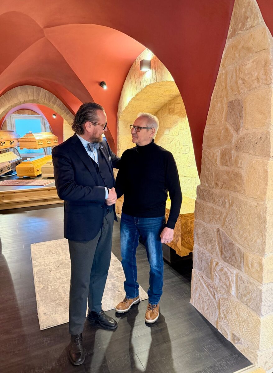 Alexander Christ von Himml Bestattungen und Sebastian Krauß von Bestattungen Krauß Neudrossenfeld schütteln sich lächelnd die Hände wegen der erfolgreichen Fortführung des traditionellen Bestattungsunternehmens.